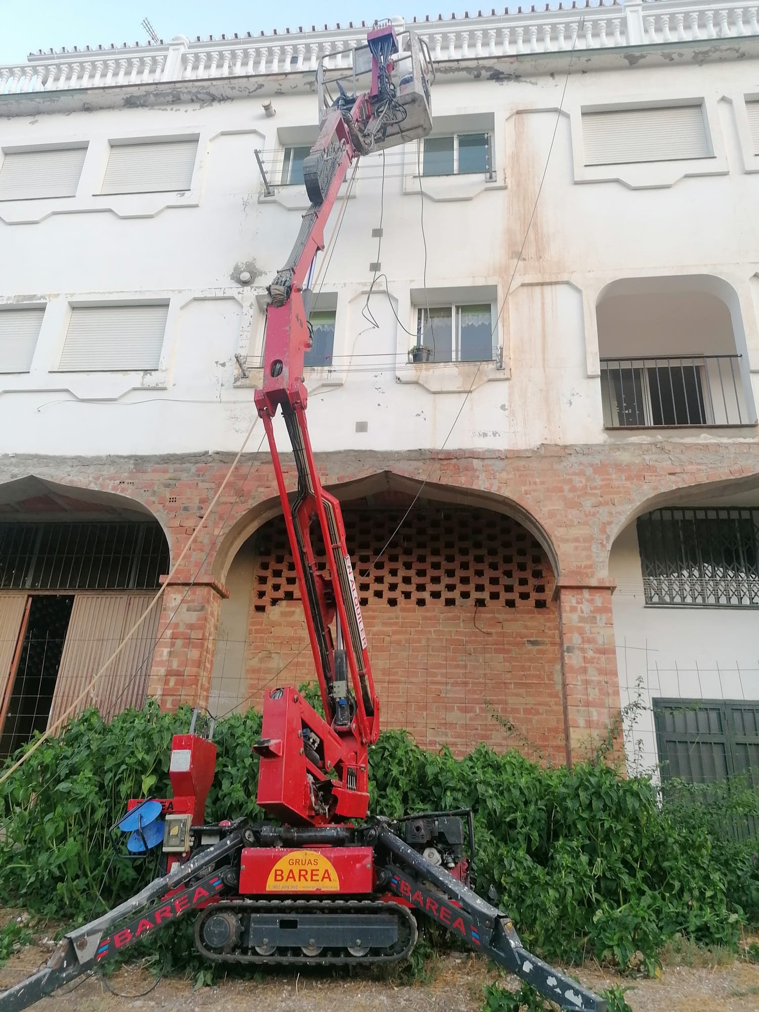 Trabajo de fachada blanca con plataforma elevadora
