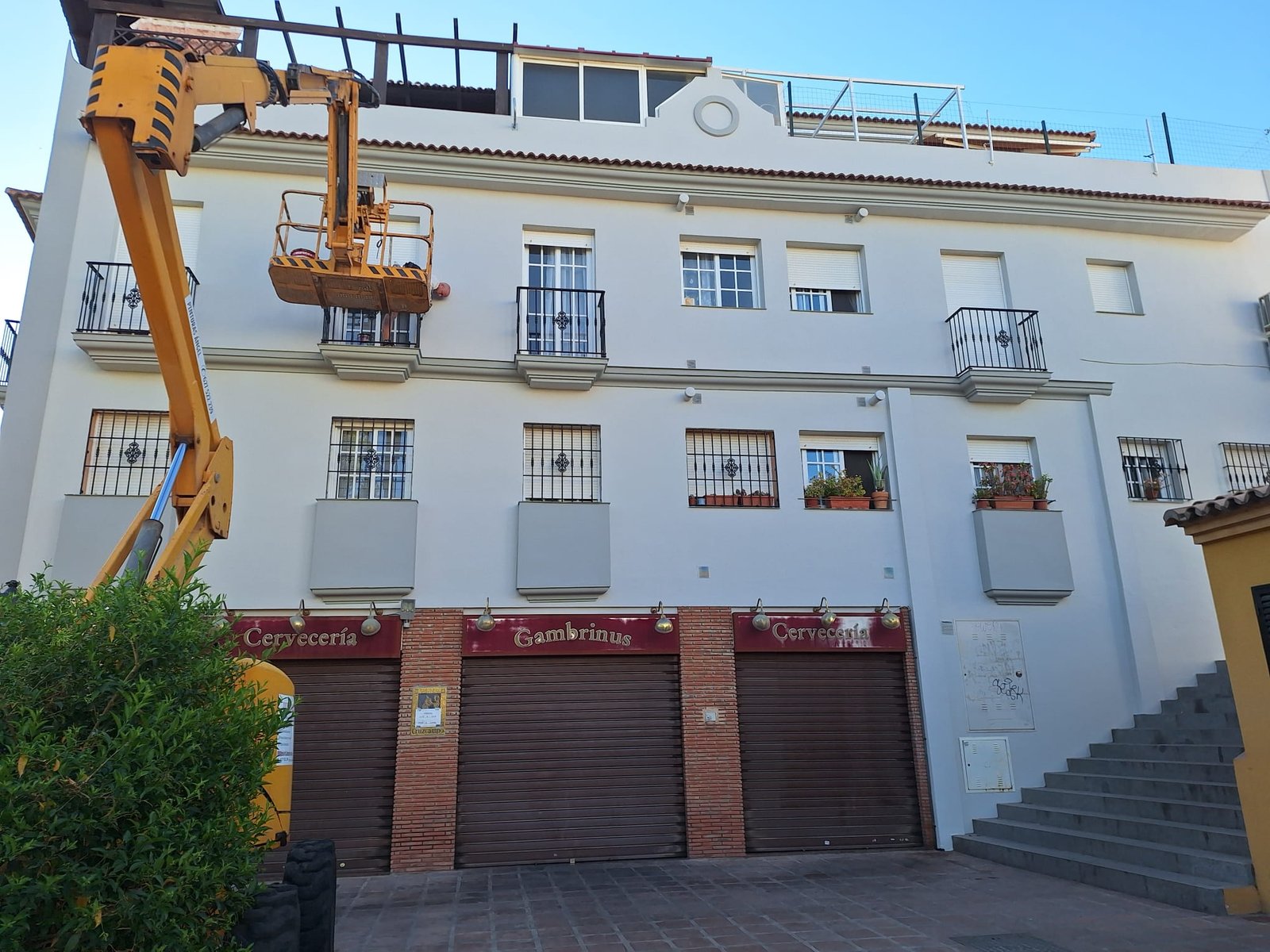 Fachada blanca con garajes renovada