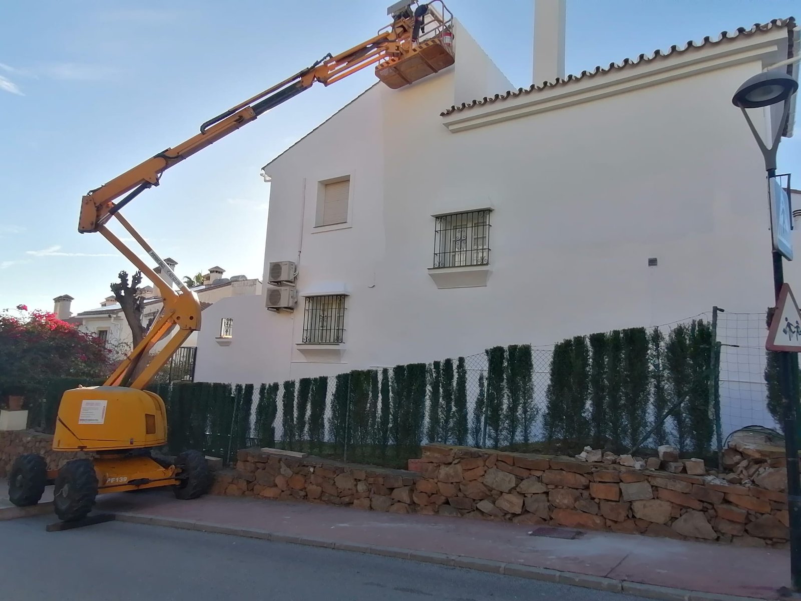 Fachada blanca con jardín y plataforma