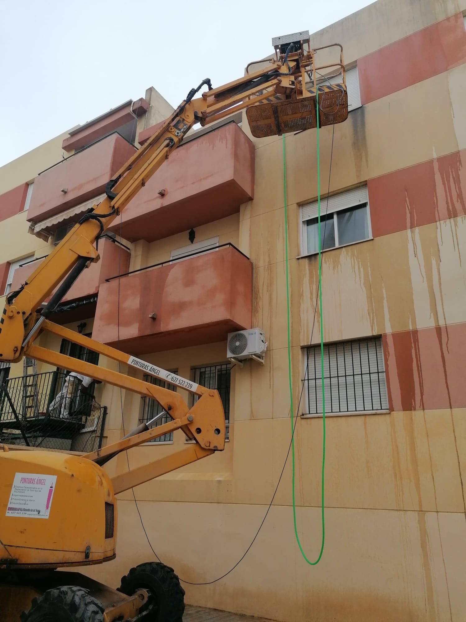 Fachada rosa con plataforma de trabajo