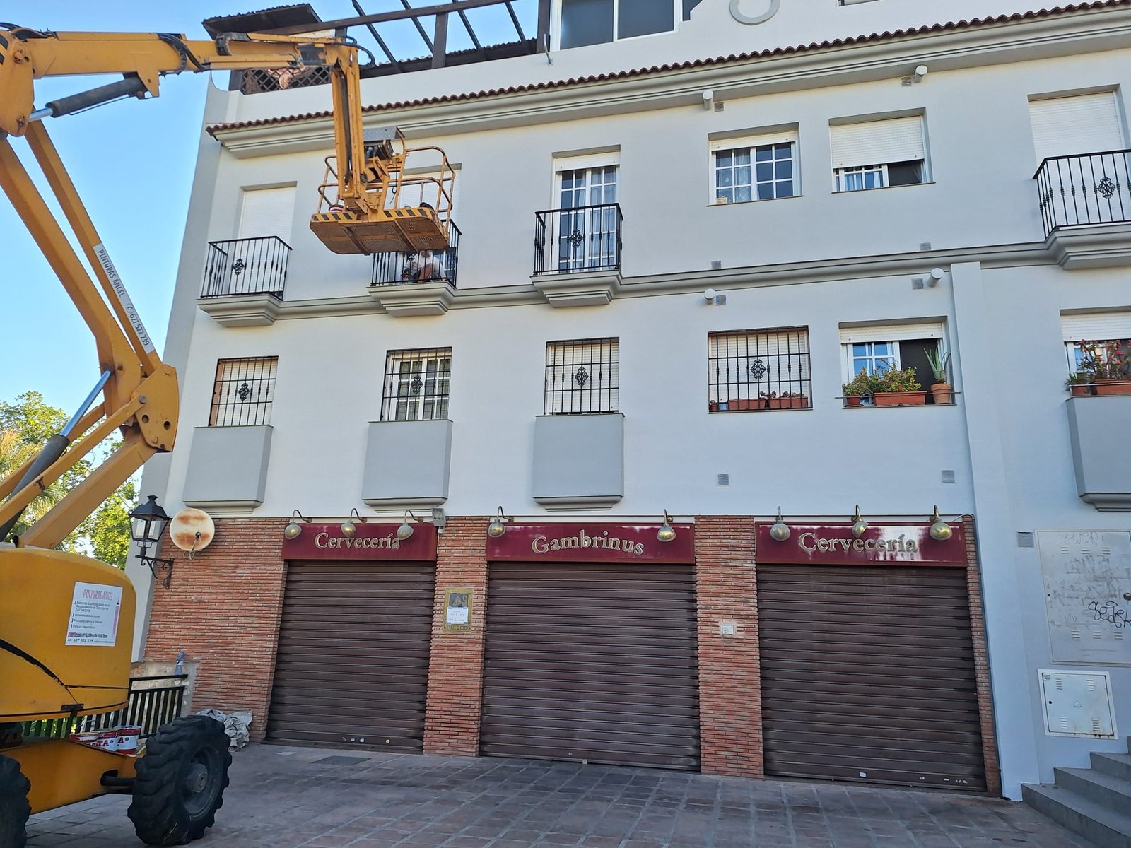 Fachada blanca con garajes y plataforma elevadora