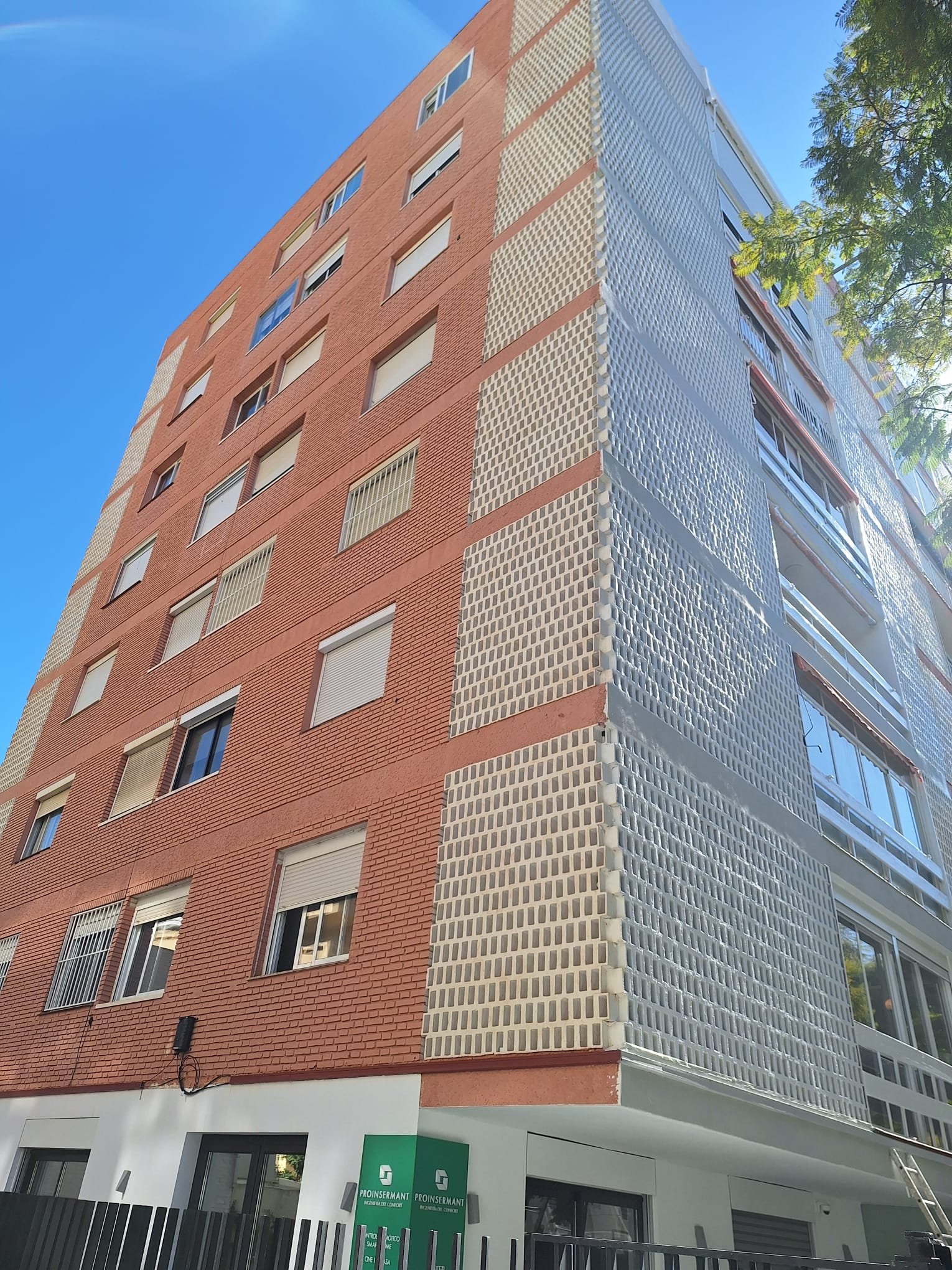 Fachada roja renovada en edificio alto