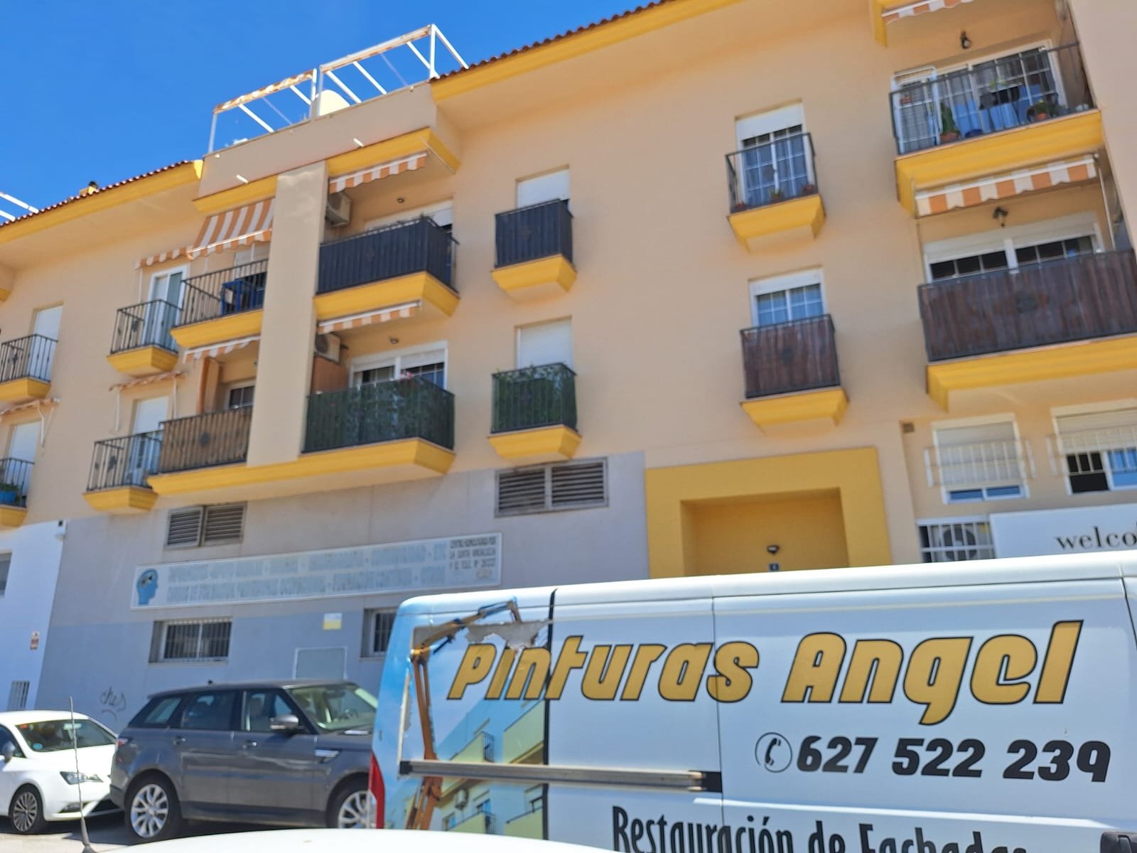 Fachada en proceso de pintura con plataforma elevadora