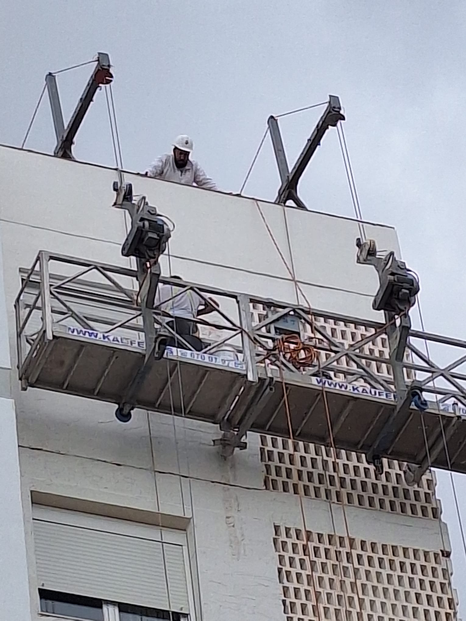Trabajadores en altura rehabilitando una fachada